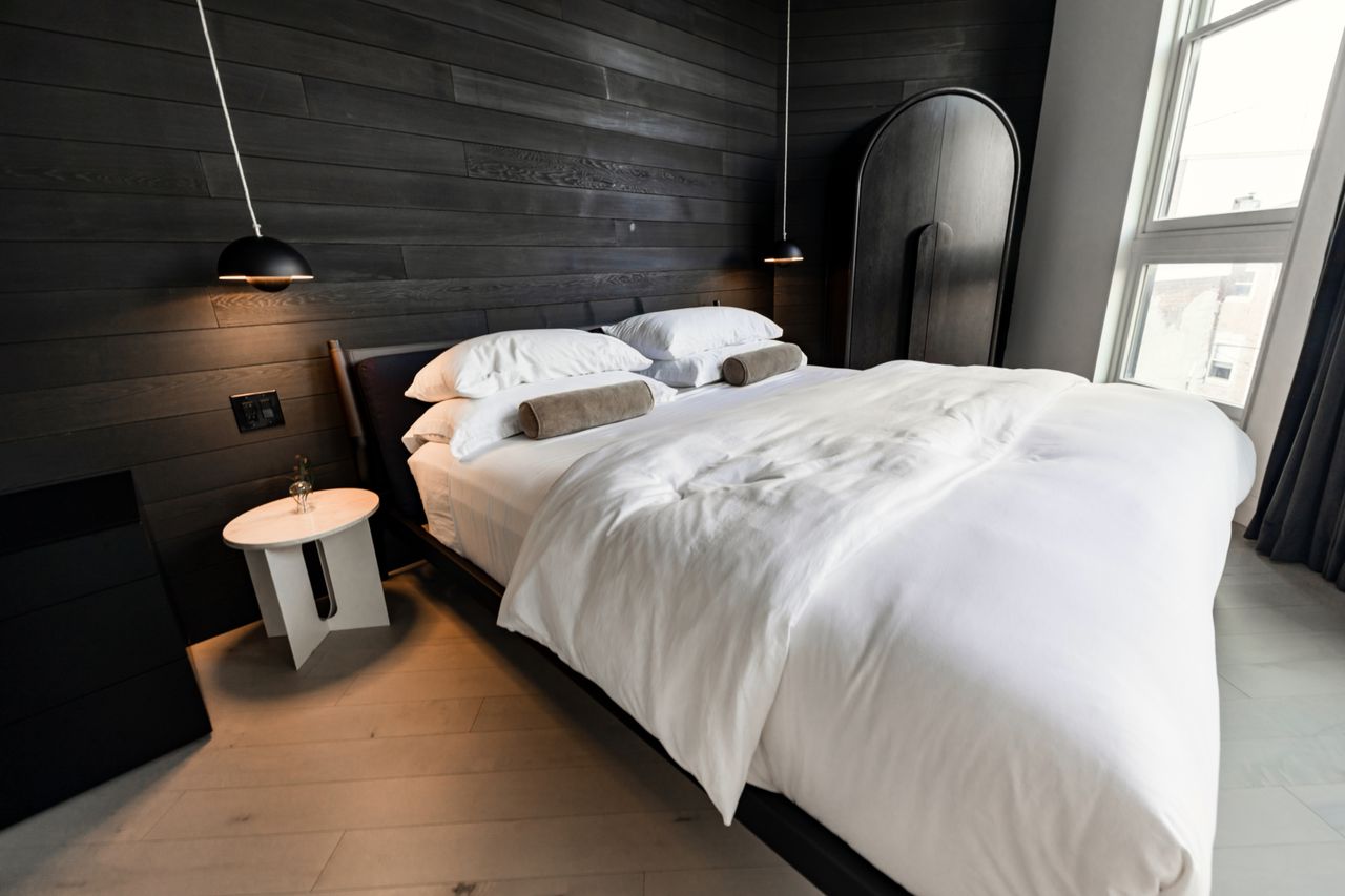 Stylish bedroom design featuring dark wood walls and contemporary furniture in a Philadelphia home.