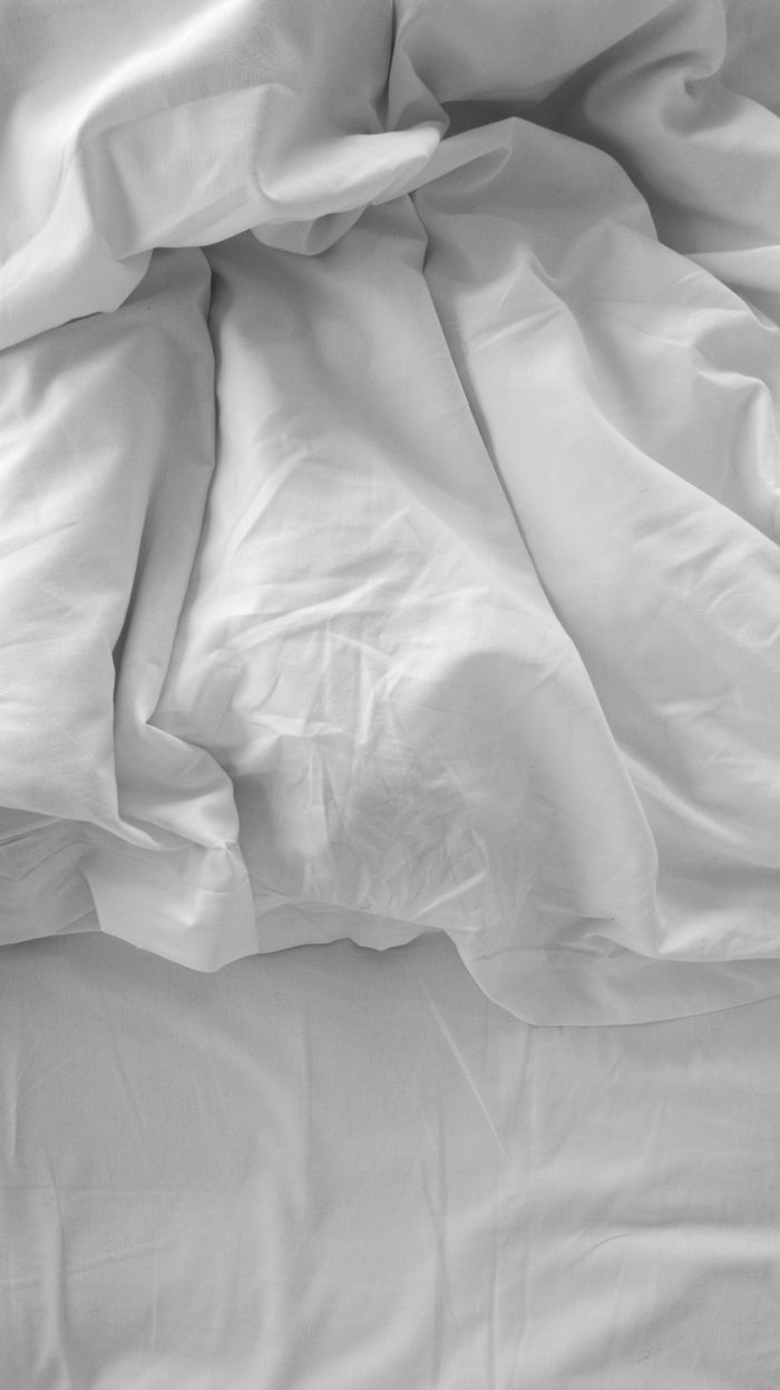 Crisp white linen bedding with a stylish, rumpled texture creating a serene atmosphere.